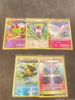 Group shot of all five Pokémon holo cards in sleeves: Natu, Swellow, Togekiss, Ludicolo, Chaos Tower