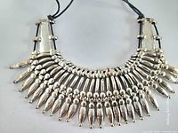Front view showing layered silvertone drops and black cord
