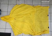 Poncho laid flat front view showing hood, extended rear panel and overall shape