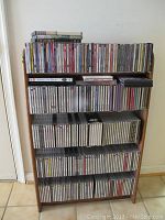 Full view of the wooden rack with five shelves containing discs