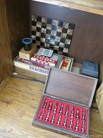 Polaroid camera and several boxed board games including Scrabble, Parcheesi, Checkers, and a folding chessboard.