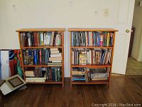 Front view of two wooden collapsible bookshelves filled with various books for scale.