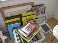 Photo of stacked various sketch pads and art paper, with yellow and blue covers, some spiral-bound.