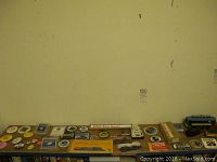 Wide view of the collection showing train model, coins, patches, stamp albums, book and buttons spread on a table.