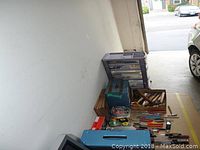 All items laid out showing variety of hand tools, toolboxes, and plastic drawer storage unit.