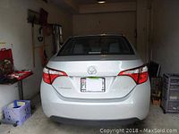 Rear exterior view of silver Toyota Corolla LE parked in garage
