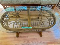 Full view of coffee table with glass top and rattan frame