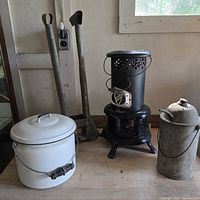 Overall lot: heater, enamel pot, kerosene can, post-hole digger