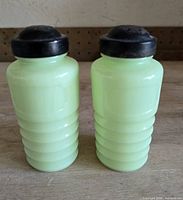 Front view of both jadeite shakers with lids attached