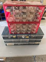 Stack of red and green drawer organizers on table
