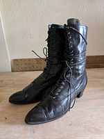 Side view of both black leather lace-up boots standing upright