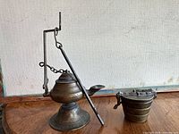 Oil lamp beside closed nesting weight set on wooden surface