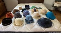 All seventeen hats laid out on mattress