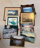 Group shot of ten framed artworks laid out on floor