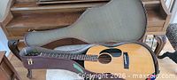 Guitar in open hard-shell case on bench