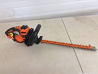Full side view showing entire hedge trimmer and blade