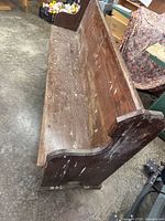Angled view of pew showing seat, backrest and finish wear