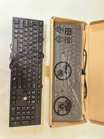 Top view of both keyboards, one unboxed used, one new in open box