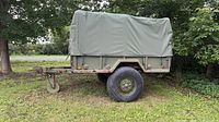 Left side view of trailer with canvas cover and landing leg