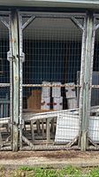 Front view of multiple attached wooden gate panels with wire mesh
