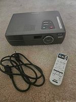 Front view of Epson PowerLite projector with remote and power cord