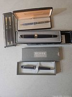 All four pen cases displayed open showing five pens