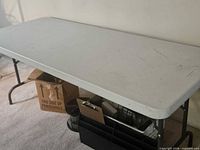 Overall view of first folding table showing top surface and legs