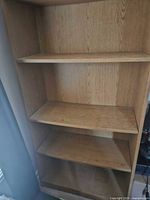 Full view of tall wooden bookcase with five shelves