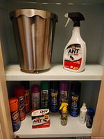 Overall view showing waste can, ant spray bottle, assorted aerosols and ant traps
