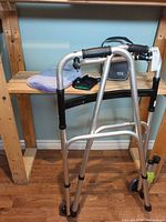 Walker with extra legs, blood pressure monitor, hot water bottle, wrist brace on shelf