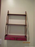 Front view of wood wall shelf showing shelves and drawers