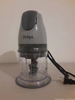 Full view of assembled Ninja food processor showing motor head, bowl, blade and cord