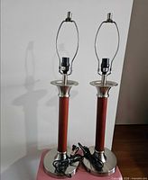 Both tall mid-century style table lamp bases with wood accents and cords visible