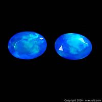 Two oval blue fire opal gemstones on black background
