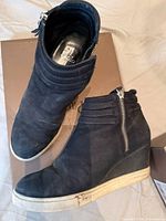 Top view of both Paolo black suede booties on box