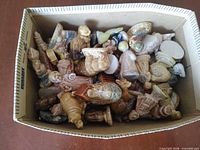 Box filled with assorted miniature Wade porcelain figurines