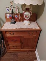 front view of solid wood sideboard buffet cabinet with lace runner and decor items on top