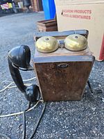 Front view showing wooden case, brass bells, black handset and wiring