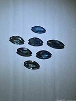 Eight marquise-cut sapphires on neutral background