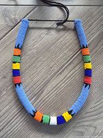 Full view of necklace showing multicolour bead pattern and black cord