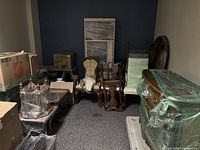 Room view showing spoon back armchair among other wrapped furniture