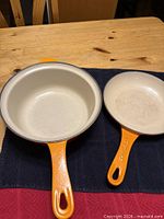 Top view of Le Creuset saucepan and skillet showing interiors and handles
