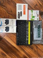 All items laid out: Logitech keyboard, two PS4 charging dock boxes, KanexPro converter box, Manhattan converter pack, sealed cable bundle
