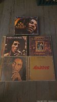 All five CD cases laid out showing cover art