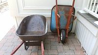 Two rusty metal wheelbarrows showing overall condition and side view details