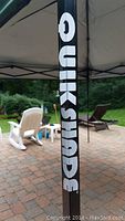 Close-up of black tent frame with white 'Quik Shade' text.