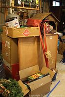 Stacked boxes and lot contents including skis and boxes of decor