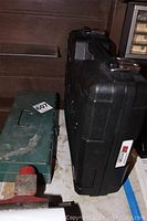 Two tool cases side by side: green metal case and black plastic Bosch case