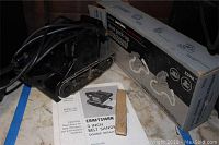 Craftsman 3 inch belt sander with power cord, sanding belt piece, instruction manual and dust pickup attachment box. Shows details of sander belt mechanism and accessories.