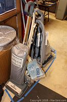 Hoover Steam Vac carpet cleaner model F5914900 with original instructions, Oreck XL vacuum, mops, buckets shown together